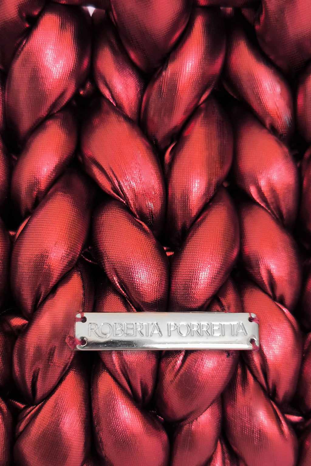 dettaglio placchetta in metallo con logo inciso Roberta Porretta