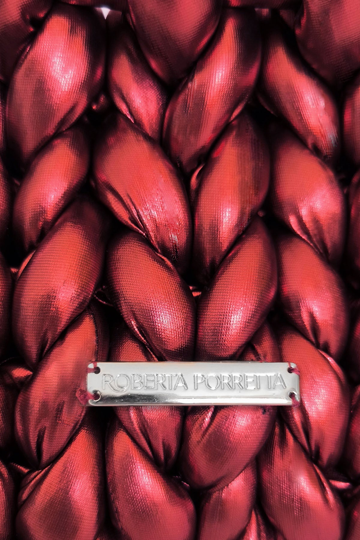 dettaglio placchetta in metallo con logo inciso Roberta Porretta